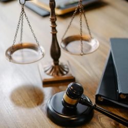 A striking image featuring a brass justice scale and gavel on a wooden desk, symbolizing law and justice.